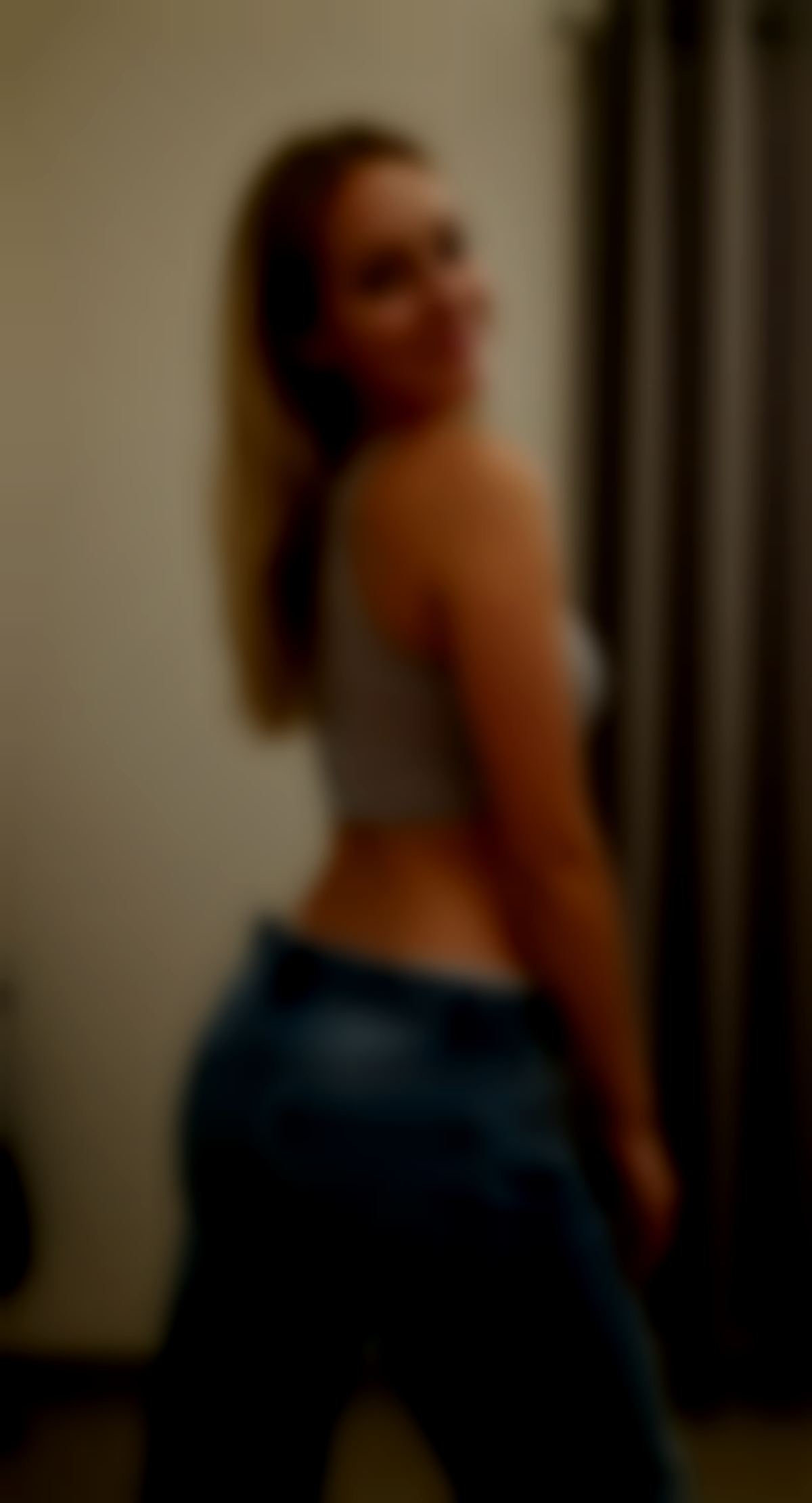 A smiling blonde in a changing room.